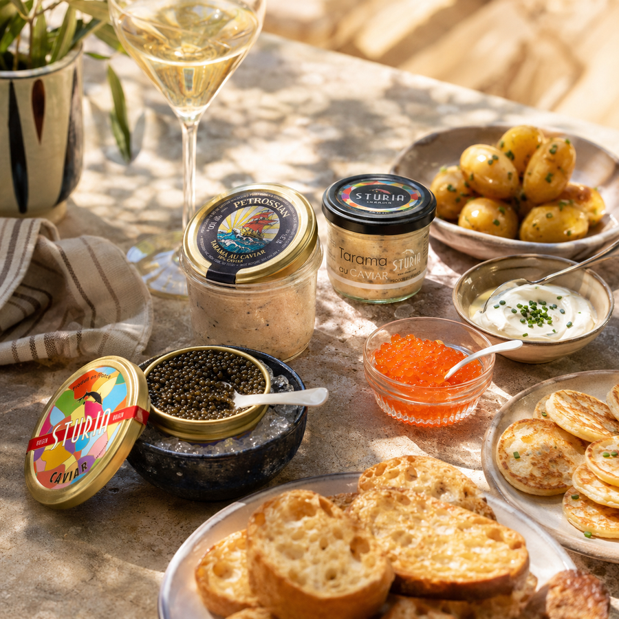 Apéritif raffiné avec tarama Pétrossian, tarama Sturia, caviar, œufs de truite, blinis, pommes de terre et verre de vin blanc.