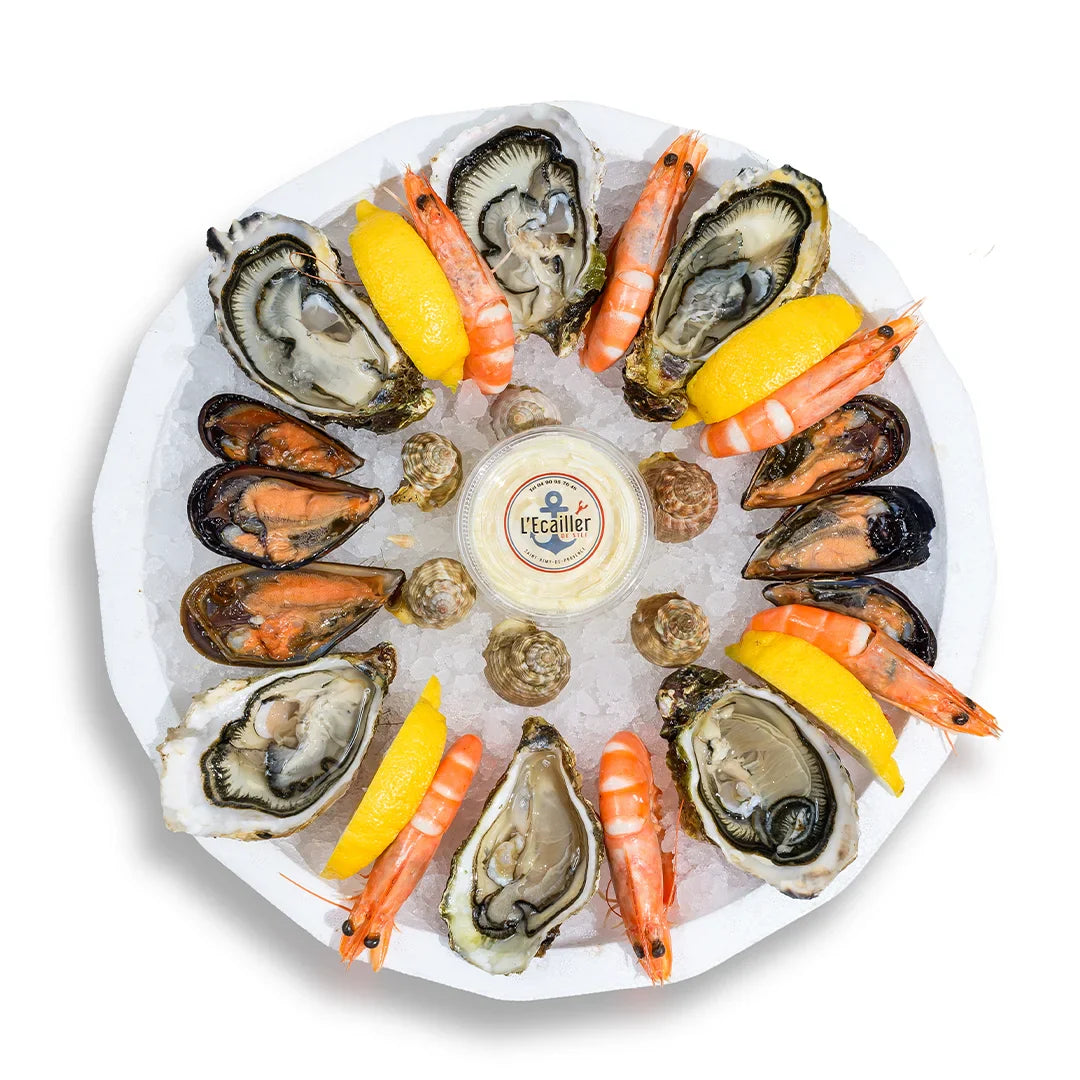 Plateau de fruits de mer sur glace avec huîtres ouvertes, crevettes roses, moules, bulots, citron et sauce maison L’Écailler de Stef.